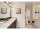 Bright bathroom featuring a double sink vanity with a marble countertop and a glass-enclosed shower at 17859 E 108Th Pl, Commerce City, CO 80022