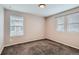 Cozy bedroom featuring plush carpeting, neutral-colored walls, and ample natural light from two windows at 17859 E 108Th Pl, Commerce City, CO 80022