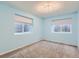 Bright bedroom featuring carpeted floors, light blue walls, and two windows for natural light at 17859 E 108Th Pl, Commerce City, CO 80022