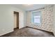 Bedroom with patterned accent wall, featuring plush carpeting and a sliding door closet at 17859 E 108Th Pl, Commerce City, CO 80022