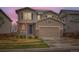 Two-story home with a two-car garage, stone accents, blue shutters, and a well-manicured front yard at 17859 E 108Th Pl, Commerce City, CO 80022