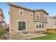 Exterior of the home featuring a concrete patio, sliding glass door, and yard at 17859 E 108Th Pl, Commerce City, CO 80022