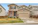 Two-story home with a two-car garage, stone accents, blue shutters, and a well-manicured front yard at 17859 E 108Th Pl, Commerce City, CO 80022