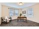 Bright home office with carpeted floors, three windows, and a wooden desk at 17859 E 108Th Pl, Commerce City, CO 80022