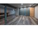 A finished basement with gray accent walls, neutral gray floors, and natural wood door at 3288 W Tufts Ave, Englewood, CO 80110