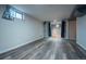 Finished basement with new gray vinyl floors and a bright window with curtains at 3288 W Tufts Ave, Englewood, CO 80110