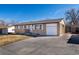Exterior view of a one-story brick home with a driveway, an attached garage, and a front yard at 3288 W Tufts Ave, Englewood, CO 80110