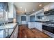 Open-concept kitchen with stainless steel appliances, granite counters, and modern lighting at 3288 W Tufts Ave, Englewood, CO 80110