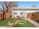 Backyard featuring new grass area surrounded by river rock and wood fence, and a detached garage at 1333 Raleigh St, Denver, CO 80204