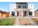 Modern townhome featuring a contemporary design, light stucco, and eye-catching red door and a gray door at 1333 Raleigh St, Denver, CO 80204