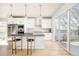 Bright kitchen featuring white cabinetry, stainless steel appliances, island with seating, and a sliding door to the patio at 1333 Raleigh St, Denver, CO 80204