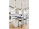 Modern kitchen with stainless steel appliances, a large island, stylish pendant lights, and herringbone backsplash at 1333 Raleigh St, Denver, CO 80204