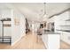 Open-concept living area with light wood floors, modern kitchen, staircase, and a view into the living room at 1333 Raleigh St, Denver, CO 80204