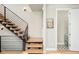 Modern staircase with open wood treads, black railing and a view into a bathroom with patterned flooring at 1333 Raleigh St, Denver, CO 80204