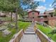 Multi-level backyard featuring wooden walkways, lush landscaping, and a backdrop of mature trees at 127 Granite Way, Evergreen, CO 80439