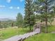 Scenic backyard with a wooden gazebo and expansive grassy area at 127 Granite Way, Evergreen, CO 80439