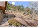 Beautiful backyard featuring stone walls, mature trees, and attractive landscaping at 127 Granite Way, Evergreen, CO 80439