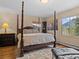 Bedroom with a four-poster bed, hardwood floors, and a view of the mountains at 127 Granite Way, Evergreen, CO 80439