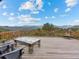 Spacious wooden deck features patio furniture and gorgeous views of the treeline and mountains at 127 Granite Way, Evergreen, CO 80439
