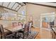 Dining room with hardwood floors, wooden beams, and large dining table next to open doorway at 127 Granite Way, Evergreen, CO 80439