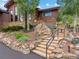 Beautiful home featuring stone accents and tiered landscaping leading to the front entrance at 127 Granite Way, Evergreen, CO 80439