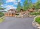 Majestic home featuring a stone facade, multi-car garage, and meticulous landscaping at 127 Granite Way, Evergreen, CO 80439