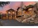 Beautiful home exterior featuring stone accents, a three-car garage, and a well-maintained driveway at 127 Granite Way, Evergreen, CO 80439