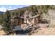 Inviting front exterior features stone accents, a landscaped yard, and convenient two-car garage at 127 Granite Way, Evergreen, CO 80439