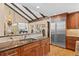 Kitchen featuring stainless steel refrigerator, hardwood floors, wooden beams and cabinets, and granite countertops at 127 Granite Way, Evergreen, CO 80439