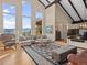 Bright and airy living room with vaulted ceilings, large windows showcasing scenic views, and a stylish seating arrangement at 127 Granite Way, Evergreen, CO 80439