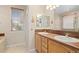 Bathroom with double sinks, warm wood cabinets, ample natural light, and neutral walls at 10650 Ashfield St, Highlands Ranch, CO 80126