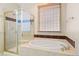 Bright bathroom featuring a glass-enclosed shower and a separate soaking tub for a spa-like experience at 10650 Ashfield St, Highlands Ranch, CO 80126