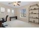 Bedroom featuring large window, ceiling fan, desk and shelving at 10650 Ashfield St, Highlands Ranch, CO 80126