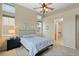 Comfortable bedroom featuring neutral walls, a ceiling fan, ample natural light, and plush carpeting at 10650 Ashfield St, Highlands Ranch, CO 80126