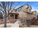 Charming two-story home featuring a stone-accented entryway and professionally landscaped front yard at 10650 Ashfield St, Highlands Ranch, CO 80126