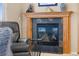 Close-up of a cozy fireplace featuring elegant wood trim and dark tile surround at 10650 Ashfield St, Highlands Ranch, CO 80126