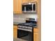 Close-up of stainless steel oven and microwave appliances, framed by sleek granite countertops and wood cabinetry at 10650 Ashfield St, Highlands Ranch, CO 80126