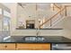 A kitchen bar area featuring a sink, granite countertop, and direct view into the adjacent living space at 10650 Ashfield St, Highlands Ranch, CO 80126