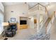 Comfortable living room with cozy fireplace, built-in shelving, and staircase leading to the upper level at 10650 Ashfield St, Highlands Ranch, CO 80126