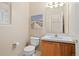 A well-lit powder room with a sink, toilet, artwork, and a large mirror at 10650 Ashfield St, Highlands Ranch, CO 80126