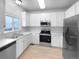 Kitchen with white cabinets, stainless steel appliances, and light wood floors at 10094 Wyandott Cir, Denver, CO 80260