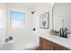 Bright bathroom featuring modern fixtures, a wood vanity, decor, and a combined tub and shower at 5554 Crystal Way, Denver, CO 80239