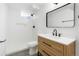Bright bathroom featuring modern fixtures, a wood vanity, and a combined tub and shower at 5554 Crystal Way, Denver, CO 80239
