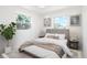 Cozy bedroom featuring bright windows, neutral decor, a soft rug and a comfortable queen sized bed at 5554 Crystal Way, Denver, CO 80239