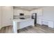 Well-lit kitchen with white cabinets, a kitchen island, stainless steel appliances, and hardwood floors at 15153 W Dequesne Ave, Morrison, CO 80465