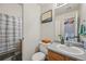 Bathroom featuring a wooden vanity, toilet, shower and a decorative painting on the wall at 19707 E Caspian Cir, Aurora, CO 80013