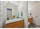 Bright bathroom featuring a wooden vanity, a large mirror, and coordinating turquoise towels at 19707 E Caspian Cir, Aurora, CO 80013