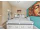 Bright bedroom showcases a white bed with drawers, complemented by a modern light fixture and colorful artwork at 19707 E Caspian Cir, Aurora, CO 80013