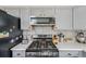 Updated kitchen showcasing stainless steel stove, microwave, and tile backsplash at 19707 E Caspian Cir, Aurora, CO 80013