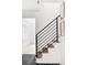 Modern staircase with white risers, wood treads, and black iron railing, leading upstairs at 6211 W Fremont Pl, Littleton, CO 80128
